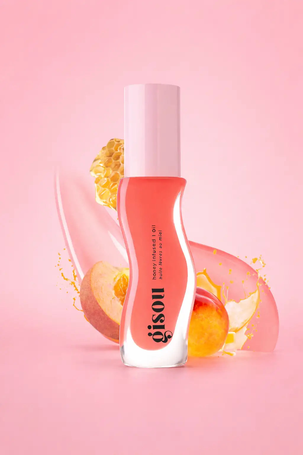 Une élégante bouteille en verre transparent avec un bouchon rose tendre contient un gloss pour les lèvres couleur pêche, infusé au miel, de la marque gisou.