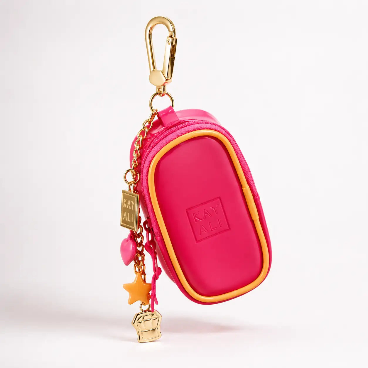 Une pochette porte-clés rose vif pour kay ali, avec une fermeture éclair et une bordure ton or, ornée de breloques pendantes comprenant un cœur, une étoile et une mini-pochette.